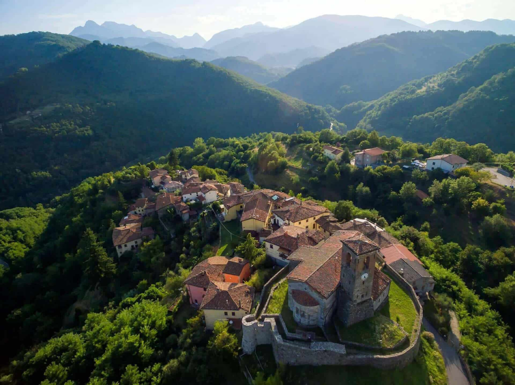 Veduta aerea di Villa Raffaelli in Garfagnana, Toscana: paesaggi montuosi suggestivi, architettura storica del 1500, ideale per vacanze autentiche e attività outdoor.